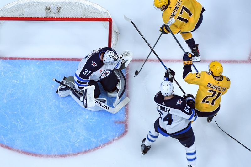 Apr 9, 2024; Nashville, Tennessee, USA; Winnipeg Jets goaltender Connor Hellebuyck (37) makes a save against Nashville Predators center Mark Jankowski (17) during the second period at Bridgestone Arena. Mandatory Credit: Christopher Hanewinckel-USA TODAY Sports