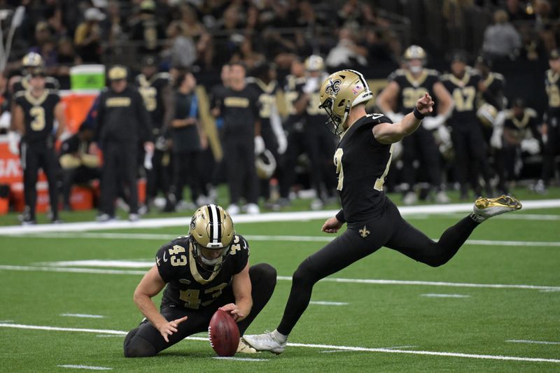 New Orleans Saints place-kicker Blake Grupe, right, kicks a field goal as punter Matthew Hayball (43) holds the ball during the first half of an NFL football game against the Carolina Panthers, Sunday, Sept. 8, 2024, in New Orleans. (AP Photo/Matthew Hinton)