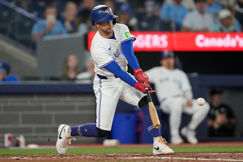 Jun 5, 2025; Toronto, Ontario, CAN; Toronto Blue Jays third baseman Ernie Clement (22) hits a double against the Philadelphia Phillies during the third inning at Rogers Centre. Mandatory Credit: John E. Sokolowski-Imagn Images