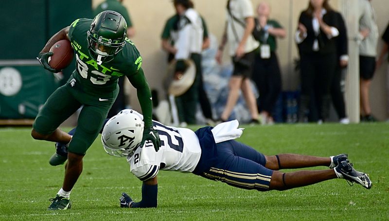 Sep 10, 2022; East Lansing, Michigan, USA;   Michigan State Spartans wide receiver Montorie Foster (83) evades 
Akron Zips linebacker Bubba Arslanian (27) in the fourth quarter. Mandatory Credit: Dale Young-USA TODAY Sports