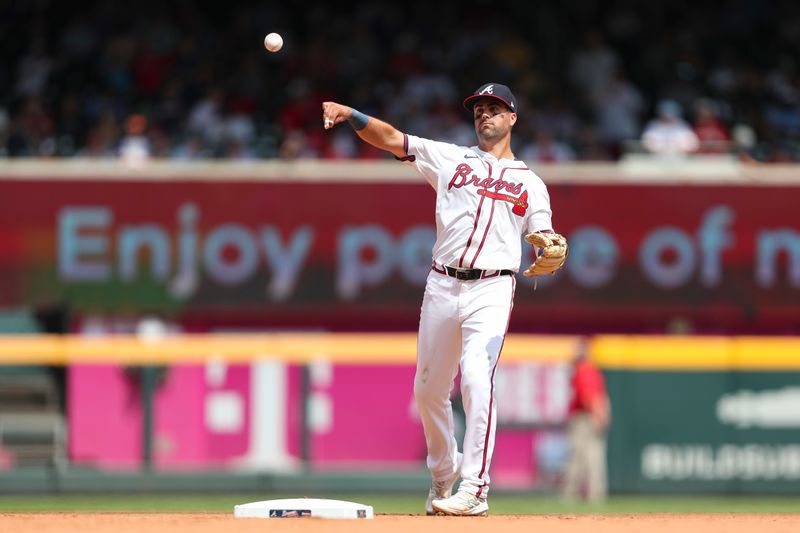 Aug 4, 2024; Cumberland, Georgia, USA; Atlanta Braves left fielder Whit Merrifield (15) throws to first base during a game against the Miami Marlins in the eight inning at Truist Park. Mandatory Credit: Mady Mertens-USA TODAY Sports