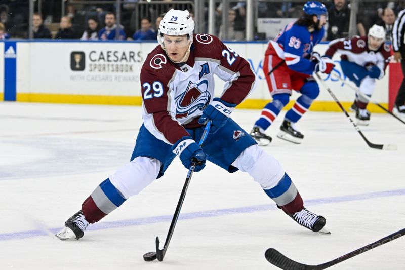 Feb 5, 2024; New York, New York, USA;  Colorado Avalanche center Nathan MacKinnon (29) skates with the puck against the New York Rangers during the second period at Madison Square Garden. Mandatory Credit: Dennis Schneidler-USA TODAY Sports