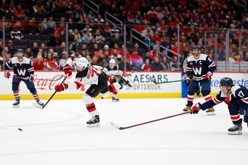 Feb 20, 2024; Washington, District of Columbia, USA; New Jersey Devils defenseman Jonas Siegenthaler (71) shoots the puck as Washington Capitals center Dylan Strome (17) defends in the first period at Capital One Arena. Mandatory Credit: Geoff Burke-USA TODAY Sports