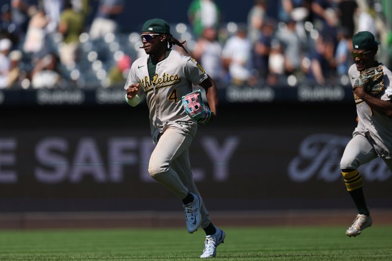 Jun 28, 2025; Bronx, New York, USA; Athletics right fielder Lawrence Butler (4) and center fielder Denzel Clarke (1) run in from the out field to celebrate with teammates after defeating the New York Yankees at Yankee Stadium. Mandatory Credit: Vincent Carchietta-Imagn Images
