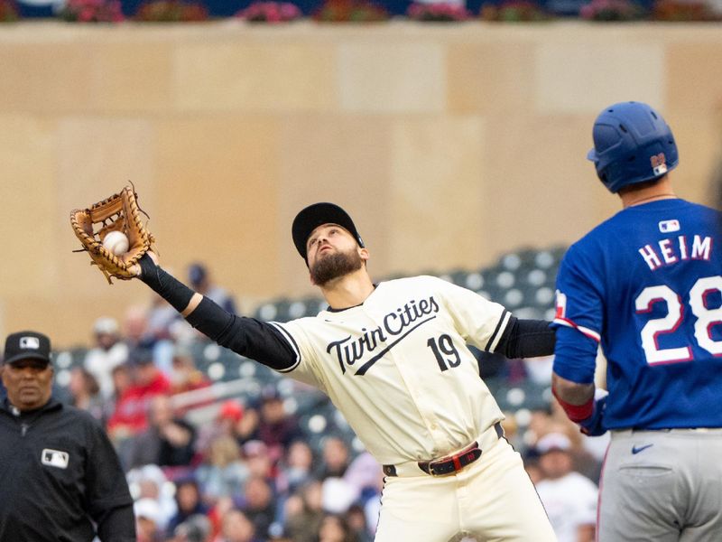 May 24, 2024; Minneapolis, Minnesota, USA; Texas Rangers catcher Jonah Heim (28) pops up to Minnesota Twins first base Alex Kirilloff (19) in the sixth inning at Target Field. Mandatory Credit: Matt Blewett-USA TODAY Sports