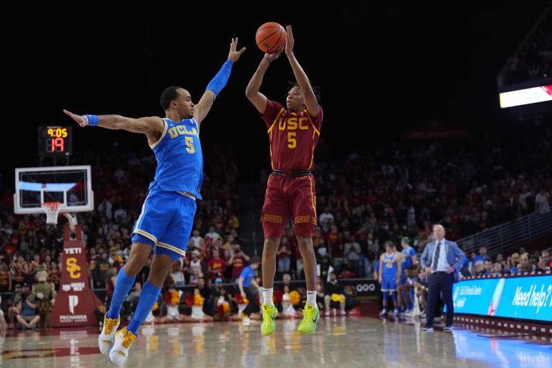 Jan 26, 2023; Los Angeles, California, USA; Southern California Trojans guard Boogie Ellis (right) shoots the ball against UCLA Bruins guard Amari Bailey in the second half at Galen Center. Mandatory Credit: Kirby Lee-USA TODAY Sports