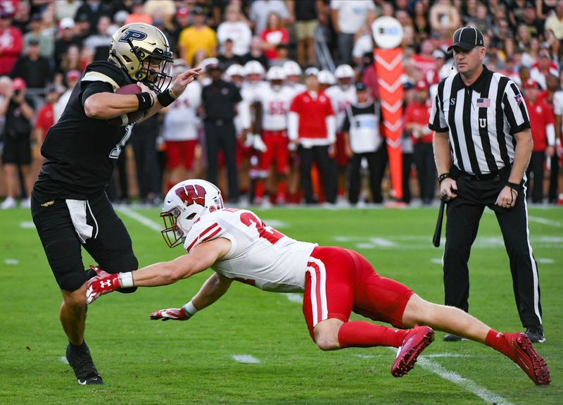 Sep 22, 2023; West Lafayette, Indiana, USA; Purdue Boilermakers quarterback Hudson Card (1) evades Wisconsin Badgers safety Hunter Wohler (24) during a run during the first half at Ross-Ade Stadium. Mandatory Credit: Robert Goddin-USA TODAY Sports