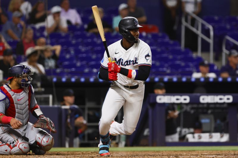 Sep 4, 2024; Miami, Florida, USA; Miami Marlins pinch hitter Jesus Sanchez (12) hits a single against the Washington Nationals during the ninth inning at loanDepot Park. Mandatory Credit: Sam Navarro-Imagn Images