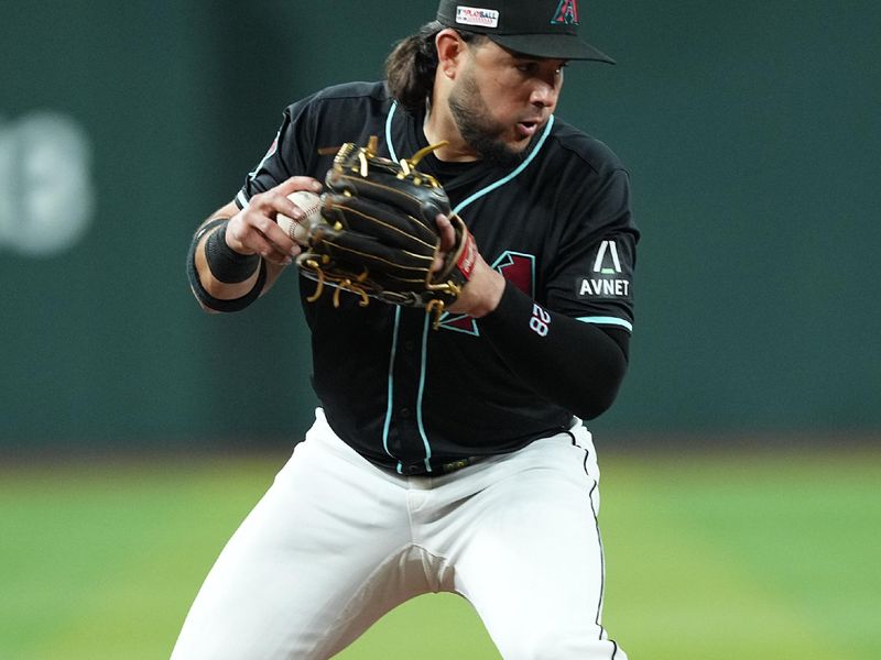 Jun 15, 2024; Phoenix, Arizona, USA; Arizona Diamondbacks third base Eugenio Suárez (28) fields a ball against the Chicago White Sox during the third inning at Chase Field. Mandatory Credit: Joe Camporeale-USA TODAY Sports