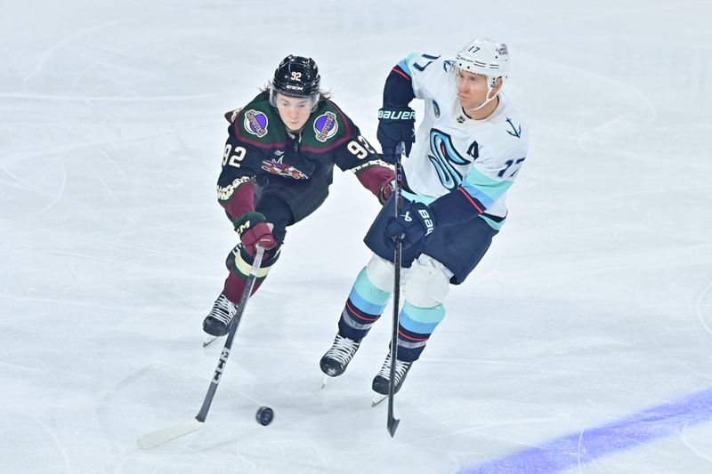 Nov 7, 2023; Tempe, Arizona, USA; Seattle Kraken center Jaden Schwartz (17) and Arizona Coyotes center Logan Cooley (92) battle for the puck in the third period at Mullett Arena. Mandatory Credit: Matt Kartozian-USA TODAY Sports