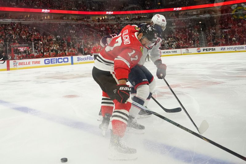 Dec 1, 2024; Chicago, Illinois, USA; Columbus Blue Jackets right wing Kirill Marchenko (86) and Chicago Blackhawks left wing Nick Foligno (17) go for the puck during the first period at United Center. Mandatory Credit: David Banks-Imagn Images