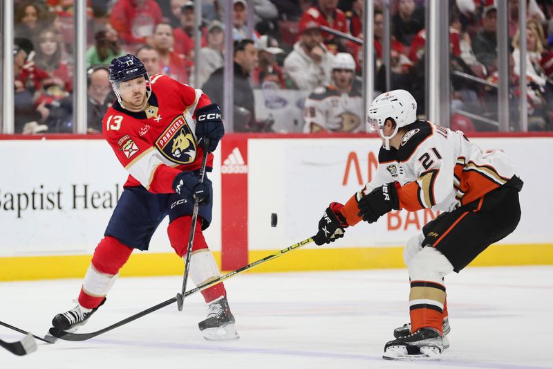 Jan 15, 2024; Sunrise, Florida, USA; Florida Panthers center Sam Reinhart (13) passes the puck as Anaheim Ducks center Isac Lundestrom (21) defends during the second period at Amerant Bank Arena. Mandatory Credit: Sam Navarro-USA TODAY Sports