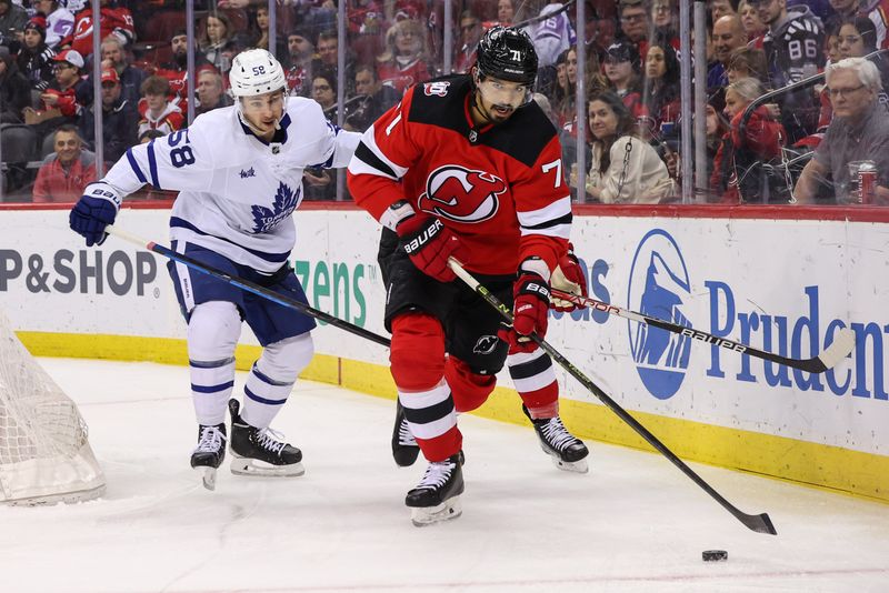 Mar 7, 2023; Newark, New Jersey, USA; New Jersey Devils defenseman Jonas Siegenthaler (71) skates with the puck while being defended by Toronto Maple Leafs left wing Michael Bunting (58) during the first period at Prudential Center. Mandatory Credit: Ed Mulholland-USA TODAY Sports