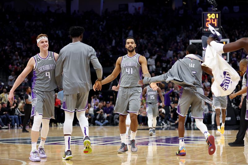 SACRAMENTO, CALIFORNIA - NOVEMBER 15: Kevin Huerter #9 and Trey Lyles #41 of the Sacramento Kings are congratulated by teammates as they come back to the bench during their game against the Brooklyn Nets at Golden 1 Center on November 15, 2022 in Sacramento, California. NOTE TO USER: User expressly acknowledges and agrees that, by downloading and or using this photograph, User is consenting to the terms and conditions of the Getty Images License Agreement.  (Photo by Ezra Shaw/Getty Images)