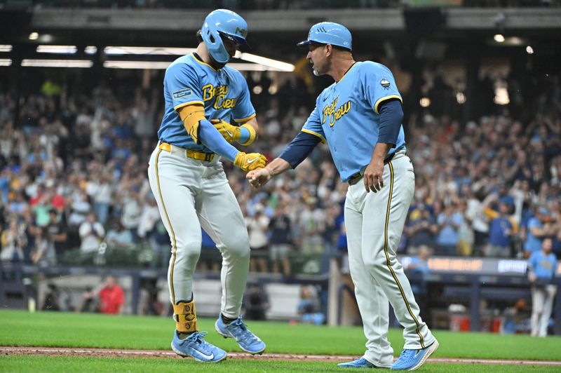 Sep 20, 2024; Milwaukee, Wisconsin, USA; Milwaukee Brewers third base coach Jason Lane (40) congratulates outfielder Garrett Mitchell (5) after hitting a home run against the Arizona Diamondbacks in the fifth inning at American Family Field. Mandatory Credit: Michael McLoone-Imagn Images