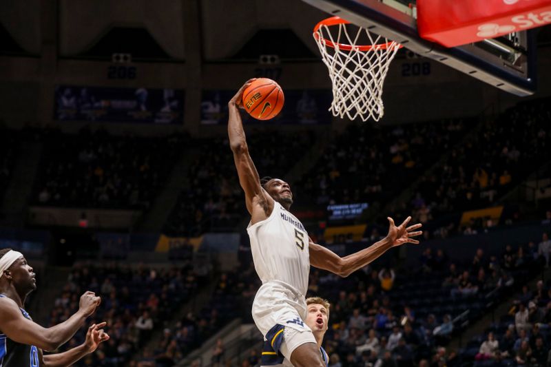 Feb 11, 2025; Morgantown, West Virginia, USA; West Virginia Mountaineers guard Toby Okani (5) dunks the ball during the first half against the Brigham Young Cougars at WVU Coliseum. Mandatory Credit: Ben Queen-Imagn Images