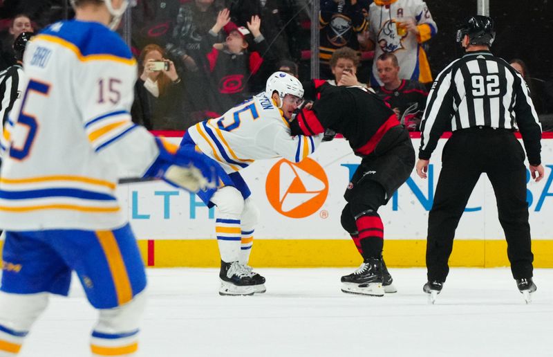 Dec 2, 2023; Raleigh, North Carolina, USA; Carolina Hurricanes center Jack Drury (18) and Buffalo Sabres defenseman Connor Clifton (75) fight during the third period at PNC Arena. Mandatory Credit: James Guillory-USA TODAY Sports