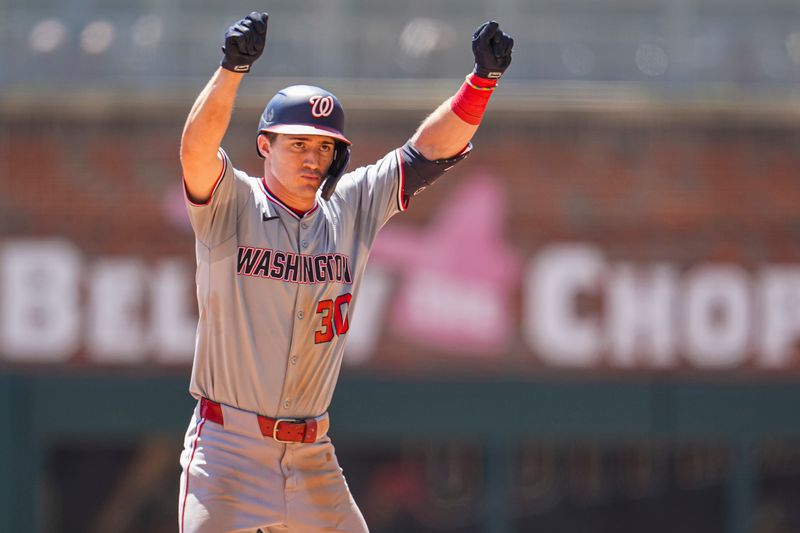 Aug 25, 2024; Cumberland, Georgia, USA; Washington Nationals center fielder Jacob Young (30) reacts after hitting a double to drive in a run against the Atlanta Braves during the seventh inning at Truist Park. Mandatory Credit: Dale Zanine-USA TODAY Sports