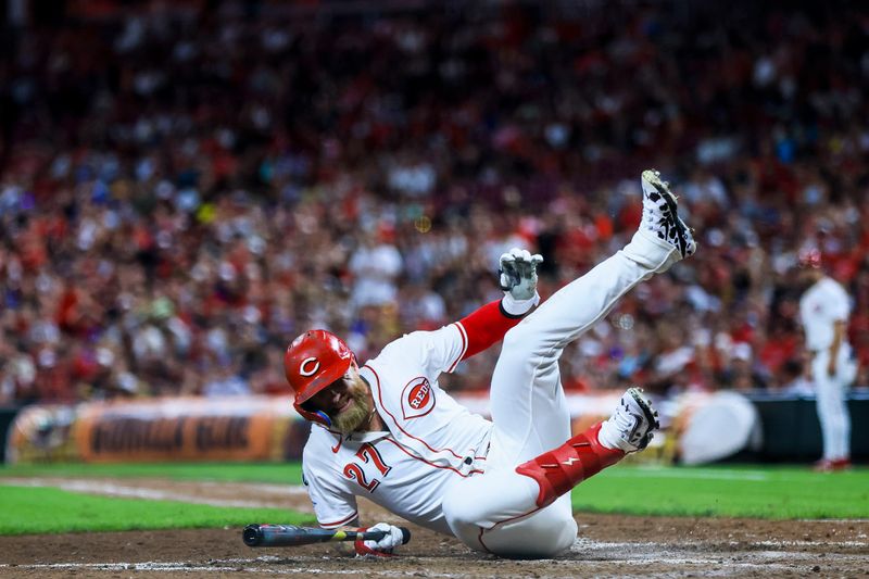 Aug 16, 2025; Cincinnati, Ohio, USA; Cincinnati Reds outfielder Jake Fraley (27) falls after a play in the ninth inning against the Milwaukee Brewers at Great American Ball Park. Mandatory Credit: Katie Stratman-Imagn Images