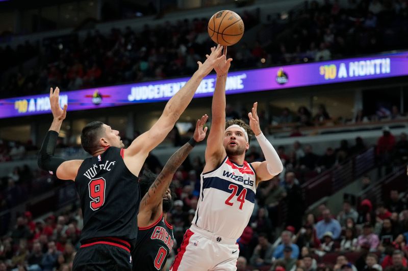 CHICAGO, ILLINOIS - MARCH 25: Corey Kispert #24 of the Washington Wizards shoots the ball against Nikola Vucevic #9 of the Chicago Bulls during the first half at the United Center on March 25, 2024 in Chicago, Illinois. NOTE TO USER: User expressly acknowledges and agrees that, by downloading and or using this photograph, User is consenting to the terms and conditions of the Getty Images License Agreement. (Photo by Patrick McDermott/Getty Images)