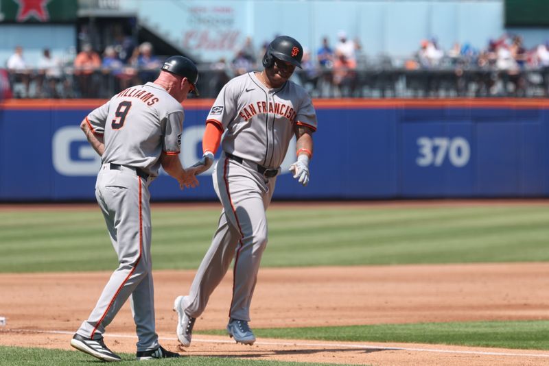 Aug 3, 2025; New York City, New York, USA;  San Francisco Giants designated hitter Rafael Devers (16) slaps hands with third base coach Matt Williams (9) while rounding third base after hitting a three run home run during the third inning against the New York Mets at Citi Field. Mandatory Credit: Vincent Carchietta-Imagn Images