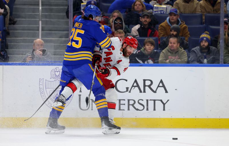 Jan 15, 2025; Buffalo, New York, USA;  Buffalo Sabres defenseman Owen Power (25) checks Carolina Hurricanes left wing Jordan Martinook (48) as he makes a pass during the first period at KeyBank Center. Mandatory Credit: Timothy T. Ludwig-Imagn Images