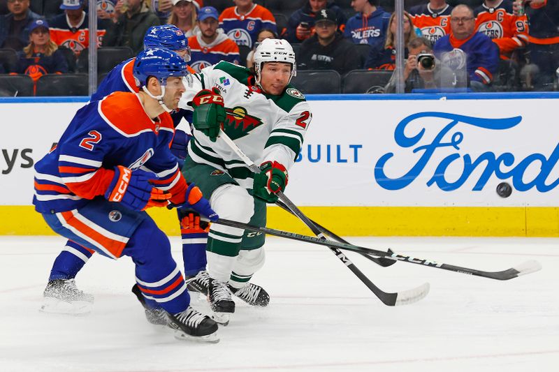 Feb 23, 2024; Edmonton, Alberta, CAN; Minnesota Wild forward Brandon Duhaime (21) tries to take a shot in front of Edmonton Oilers defensemen Evan Bouchard (2) during the second period at Rogers Place. Mandatory Credit: Perry Nelson-USA TODAY Sports