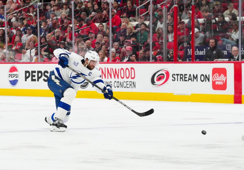 Oct 11, 2024; Raleigh, North Carolina, USA;  Tampa Bay Lightning defenseman Victor Hedman (77) takes a shot against the Carolina Hurricanes during the second period at PNC Arena. Mandatory Credit: James Guillory-Imagn Images