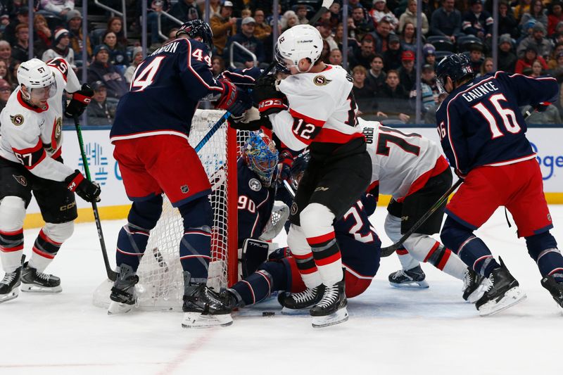 Jan 20, 2026; Columbus, Ohio, USA; Columbus Blue Jackets goalie Elvis Merzlikins (90) makes a save as Ottawa Senators center Shane Pinto (12) looks for a rebound during the first period at Nationwide Arena. Mandatory Credit: Russell LaBounty-Imagn Images