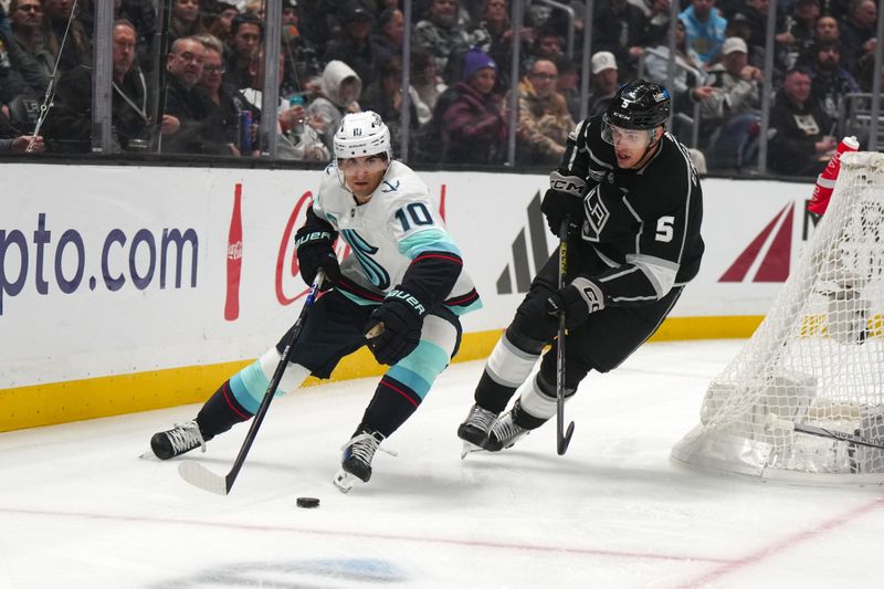 Dec 20, 2023; Los Angeles, California, USA; Seattle Kraken center Matty Beniers (10) and LA Kings defenseman Andreas Englund (5) battle for the puck in the first period at Crypto.com Arena. Mandatory Credit: Kirby Lee-USA TODAY Sports