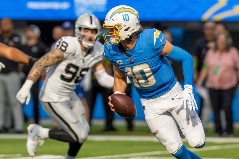 Los Angeles Chargers quarterback Justin Herbert (10) rolls out against the Las Vegas Raiders in an NFL football game, Sunday, Oct. 1, 2023, in Inglewood, Calif. Chargers won 24-17. (AP Photo/Jeff Lewis)