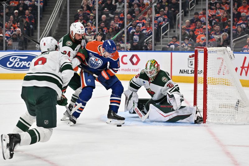 Dec 2, 2025; Edmonton, Alberta, CAN;  Minnesota Wild defenseman Zach Bogosian (24) and Edmonton Oilers left wing Zach Hyman (18) battle in front of Minnesota Wild goalie Jesper Wallstedt (30) during the third period at Rogers Place. Mandatory Credit: Walter Tychnowicz-Imagn Images