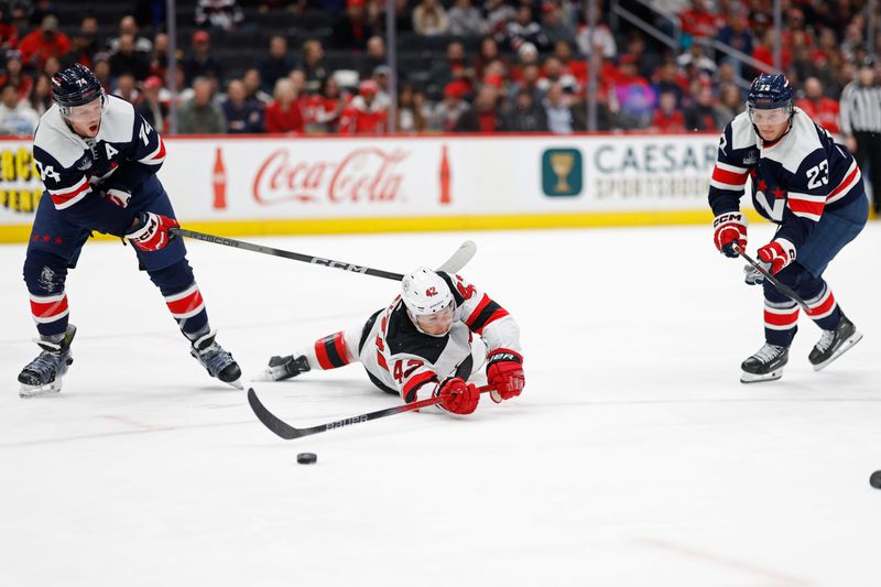Feb 20, 2024; Washington, District of Columbia, USA; New Jersey Devils center Curtis Lazar (42) battles for the puck with Washington Capitals defenseman John Carlson (74) and Capitals center Michael Sgarbossa (23) in the first period at Capital One Arena. Mandatory Credit: Geoff Burke-USA TODAY Sports