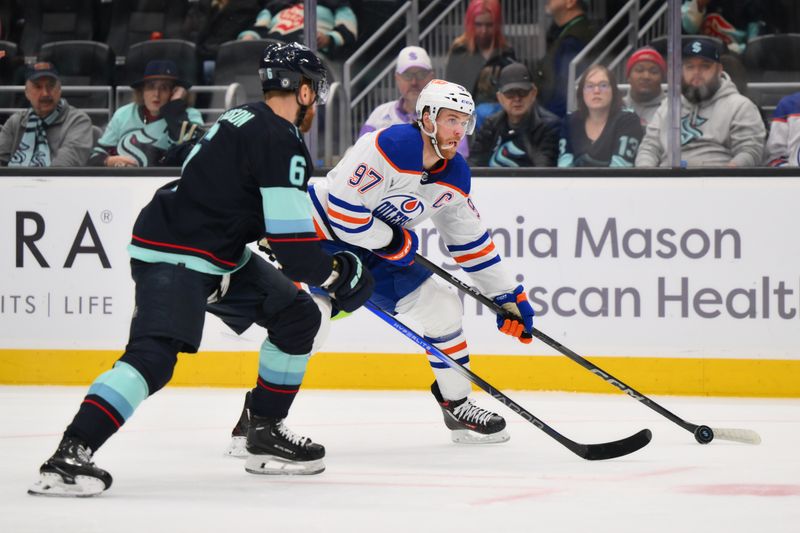 Mar 2, 2024; Seattle, Washington, USA; Edmonton Oilers center Connor McDavid (97) looks to pass the puck while defended by Seattle Kraken defenseman Adam Larsson (6) during the first period at Climate Pledge Arena. Mandatory Credit: Steven Bisig-USA TODAY Sports