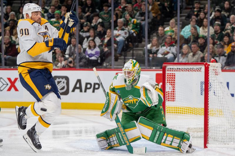 Dec 31, 2024; Saint Paul, Minnesota, USA; Nashville Predators center Ryan O'Reilly (90) is hit by a shot as Minnesota Wild goaltender Filip Gustavsson (32) defends the goal in the third period at Xcel Energy Center. Mandatory Credit: Matt Blewett-Imagn Images