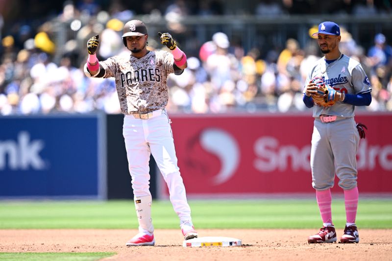 May 12, 2024; San Diego, California, USA; San Diego Padres designated hitter Luis Arraez (4) celebrates after hitting a double as Los Angeles Dodgers shortstop Mookie Betts (50) looks on during the second inning at Petco Park. Mandatory Credit: Orlando Ramirez-USA TODAY Sports