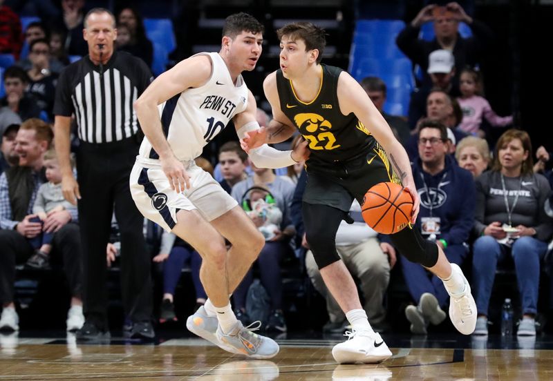 Jan 1, 2023; University Park, Pennsylvania, USA; Iowa Hawkeyes forward Patrick McCaffery (22) dribbles the ball around Penn State Nittany Lions guard Andrew Funk (10) during the first half at Bryce Jordan Center. Mandatory Credit: Matthew OHaren-USA TODAY Sports