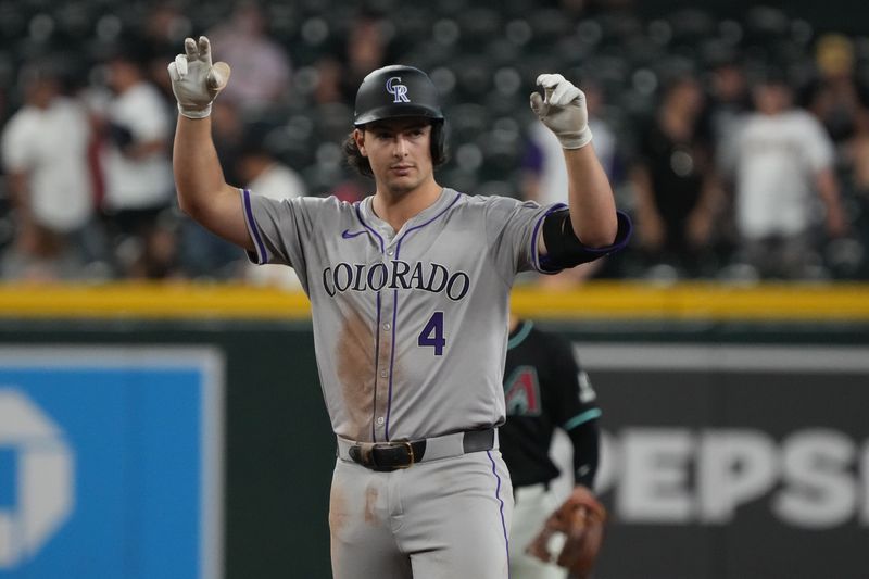 Aug 14, 2024; Phoenix, Arizona, USA; Colorado Rockies first base Michael Toglia (4) reacts after hitting a double against the Arizona Diamondbacks in the sixth inning at Chase Field. Mandatory Credit: Rick Scuteri-USA TODAY Sports