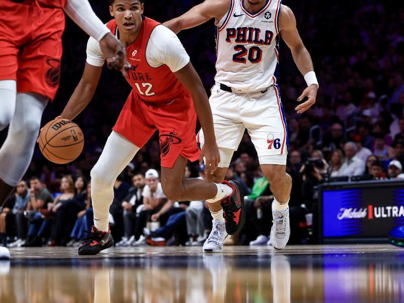 MIAMI, FLORIDA - NOVEMBER 18: Dru Smith #12 of the Miami Heat drives ahead of Jared McCain #20 of the Philadelphia 76ers during the second half at Kaseya Center on November 18, 2024 in Miami, Florida. NOTE TO USER: User expressly acknowledges and agrees that, by downloading and or using this Photograph, user is consenting to the terms and conditions of the Getty Images License Agreement.  (Photo by Carmen Mandato/Getty Images)