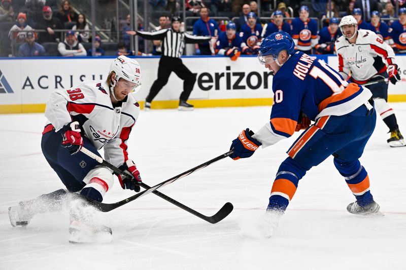 Dec 29, 2023; Elmont, New York, USA; Washington Capitals defenseman Rasmus Sandin (38) defends against the shot by New York Islanders right wing Simon Holmstrom (10) during the second period at UBS Arena. Mandatory Credit: Dennis Schneidler-USA TODAY Sports