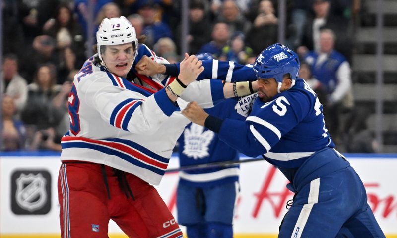 Mar 2, 2024; Toronto, Ontario, CAN; Toronto Maple Leafs forward Ryan Reaves (75) lands a punch as he fights with New York Rangers forward Matt Rempe (73) in the third period at Scotiabank Arena. Mandatory Credit: Dan Hamilton-USA TODAY Sports