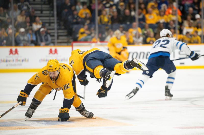 Nov 23, 2024; Nashville, Tennessee, USA;  Nashville Predators center Tommy Novak (82) upends defenseman Alexandre Carrier (45) against the Winnipeg Jets during the first period at Bridgestone Arena. Mandatory Credit: Steve Roberts-Imagn Images