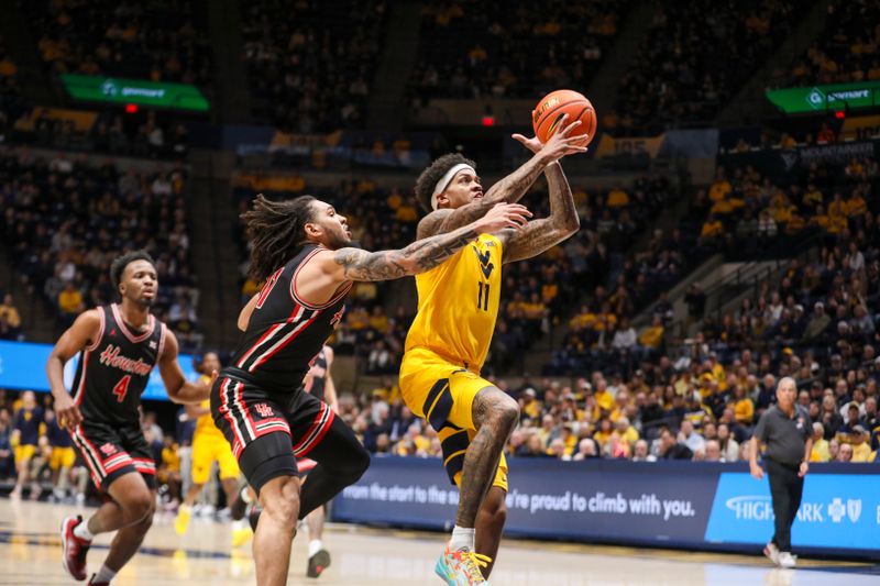 Jan 29, 2025; Morgantown, West Virginia, USA; West Virginia Mountaineers guard Jonathan Powell (11) shoots against Houston Cougars forward Joseph Tugler (11) during the first half at WVU Coliseum. Mandatory Credit: Ben Queen-Imagn Images
