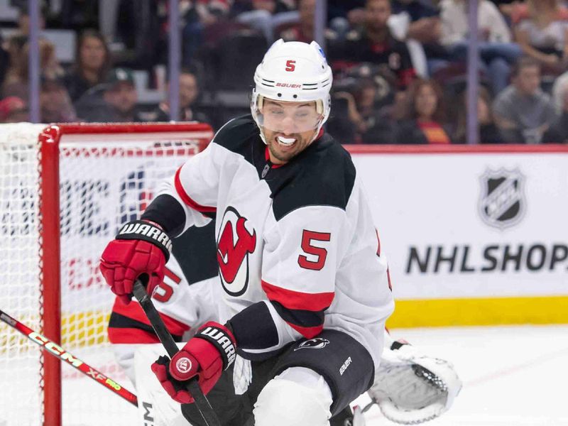 Oct 17, 2024; Ottawa, Ontario, CAN; New Jersey Devils defenseman Brenden Dillon (5) chases the puck in hte first period against the Ottawa Senators at the Canadian Tire Centre. Mandatory Credit: Marc DesRosiers-Imagn Images