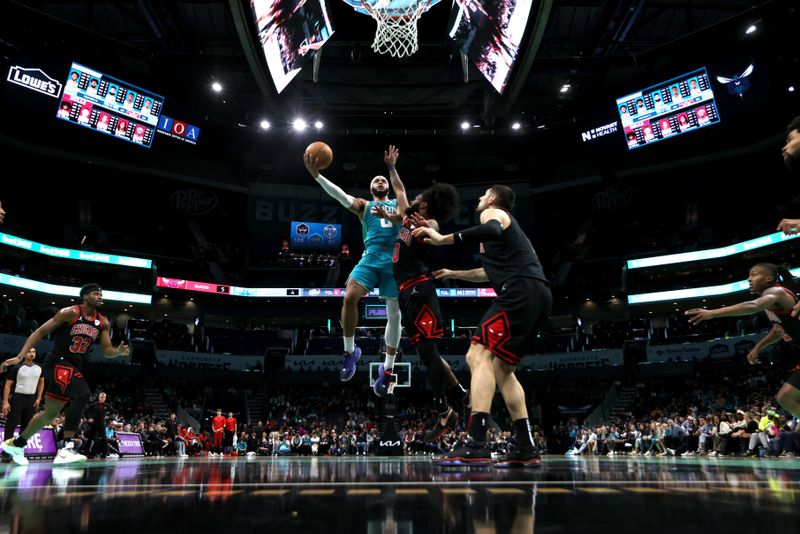 CHARLOTTE, NORTH CAROLINA - JANUARY 31: Miles Bridges #0 of the Charlotte Hornets lays the ball up over Coby White #0 of the Chicago Bulls during the second half of an NBA game at Spectrum Center on January 31, 2024 in Charlotte, North Carolina. NOTE TO USER: User expressly acknowledges and agrees that, by downloading and or using this photograph, User is consenting to the terms and conditions of the Getty Images License Agreement. (Photo by David Jensen/Getty Images)