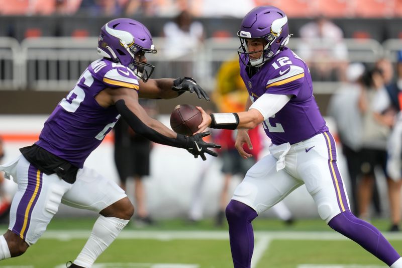 Minnesota Vikings quarterback Nick Mullens (12) hands off to running back Kene Nwangwu (26) during the first half of an NFL preseason football game against the Cleveland Browns, Saturday, Aug. 17, 2024, in Cleveland. (AP Photo/Sue Ogrocki)