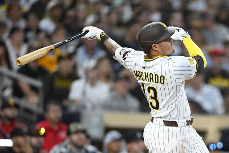 May 26, 2025; San Diego, California, USA; San Diego Padres third baseman Manny Machado (13) hits a solo home run during the eighth inning against the Miami Marlins at Petco Park. Mandatory Credit: Denis Poroy-Imagn Images