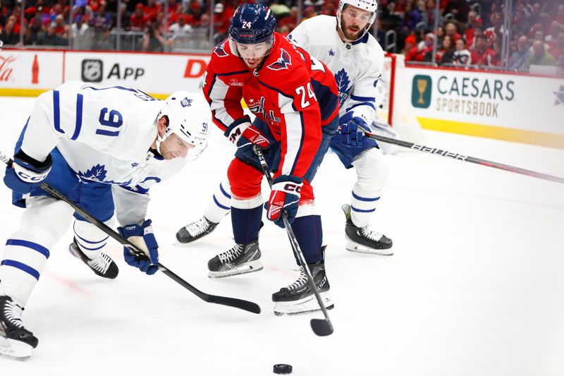 Mar 20, 2024; Washington, District of Columbia, USA; Washington Capitals center Connor McMichael (24) and Toronto Maple Leafs center John Tavares (91) battle for the puck during the first period at Capital One Arena. Mandatory Credit: Amber Searls-USA TODAY Sports