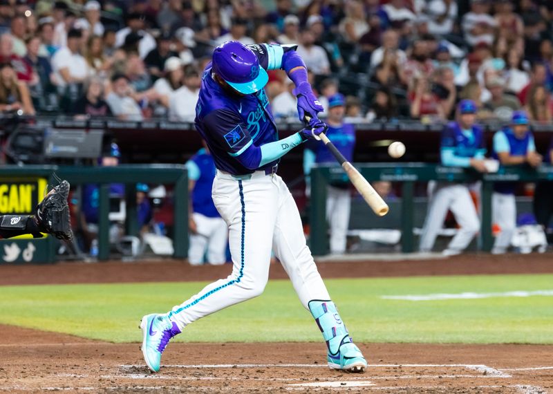 May 30, 2025; Phoenix, Arizona, USA; Arizona Diamondbacks outfielder Lourdes Gurriel Jr. hits an RBI single in the third inning against the Washington Nationals at Chase Field. Mandatory Credit: Mark J. Rebilas-Imagn Images