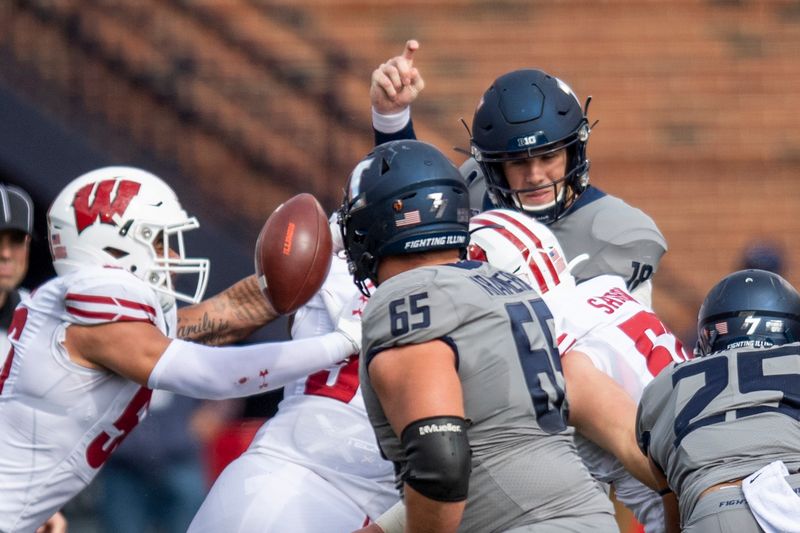 Oct 19, 2019; Champaign, IL, USA; The Wisconsin Badgers force a fumble on Illinois Fighting Illini quarterback Brandon Peters (upper, right) during the first half at Memorial Stadium. Mandatory Credit: Patrick Gorski-USA TODAY Sports